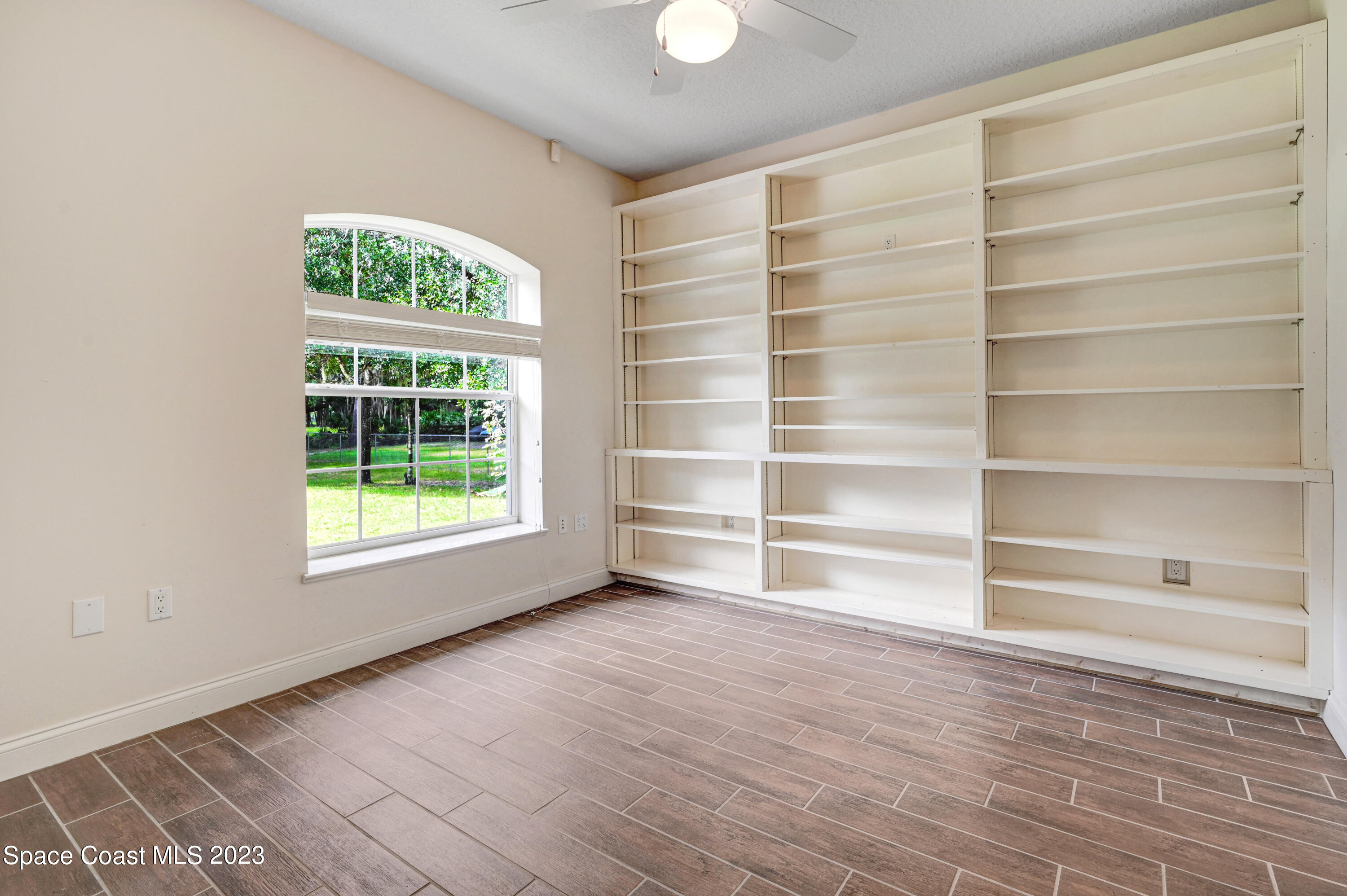 1074 Gray Road Cocoa, FL 32926 - Photo 29 of 47 a view of an empty room with a window and wooden floor