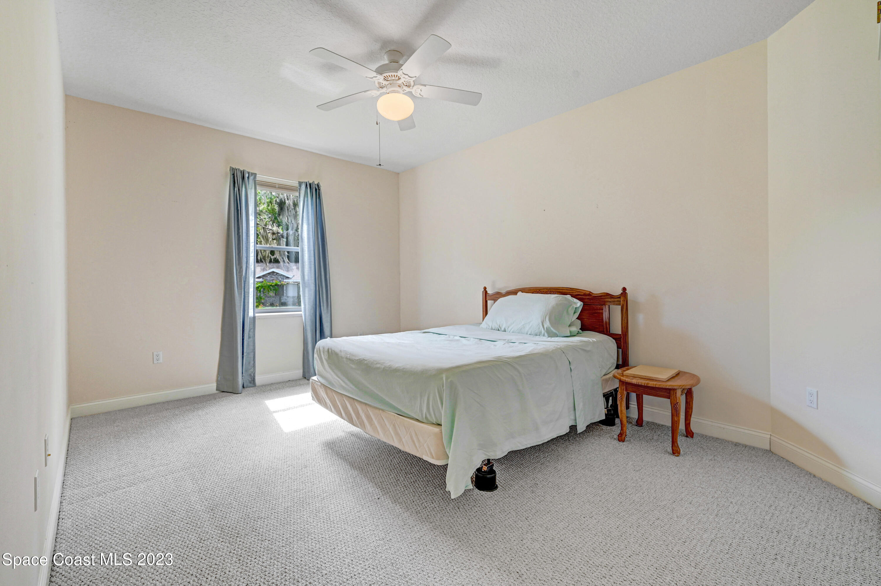 1074 Gray Road Cocoa, FL 32926 - Photo 30 of 47 a spacious bedroom with a bed and a chandelier