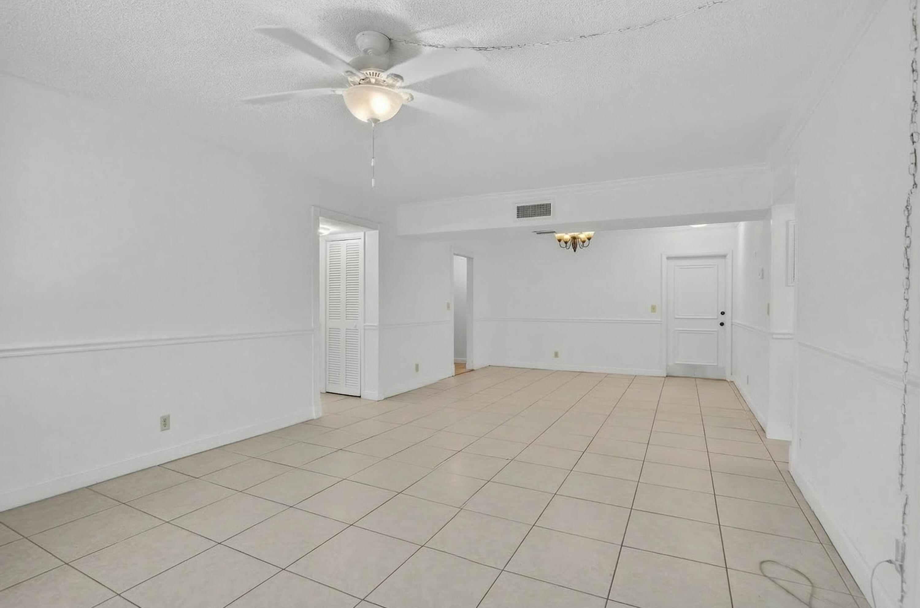 636 Northwest 13th Street, Unit 110 Boca Raton, FL 33486 - Photo 10 of 35 an empty room with a ceiling fan and a rug