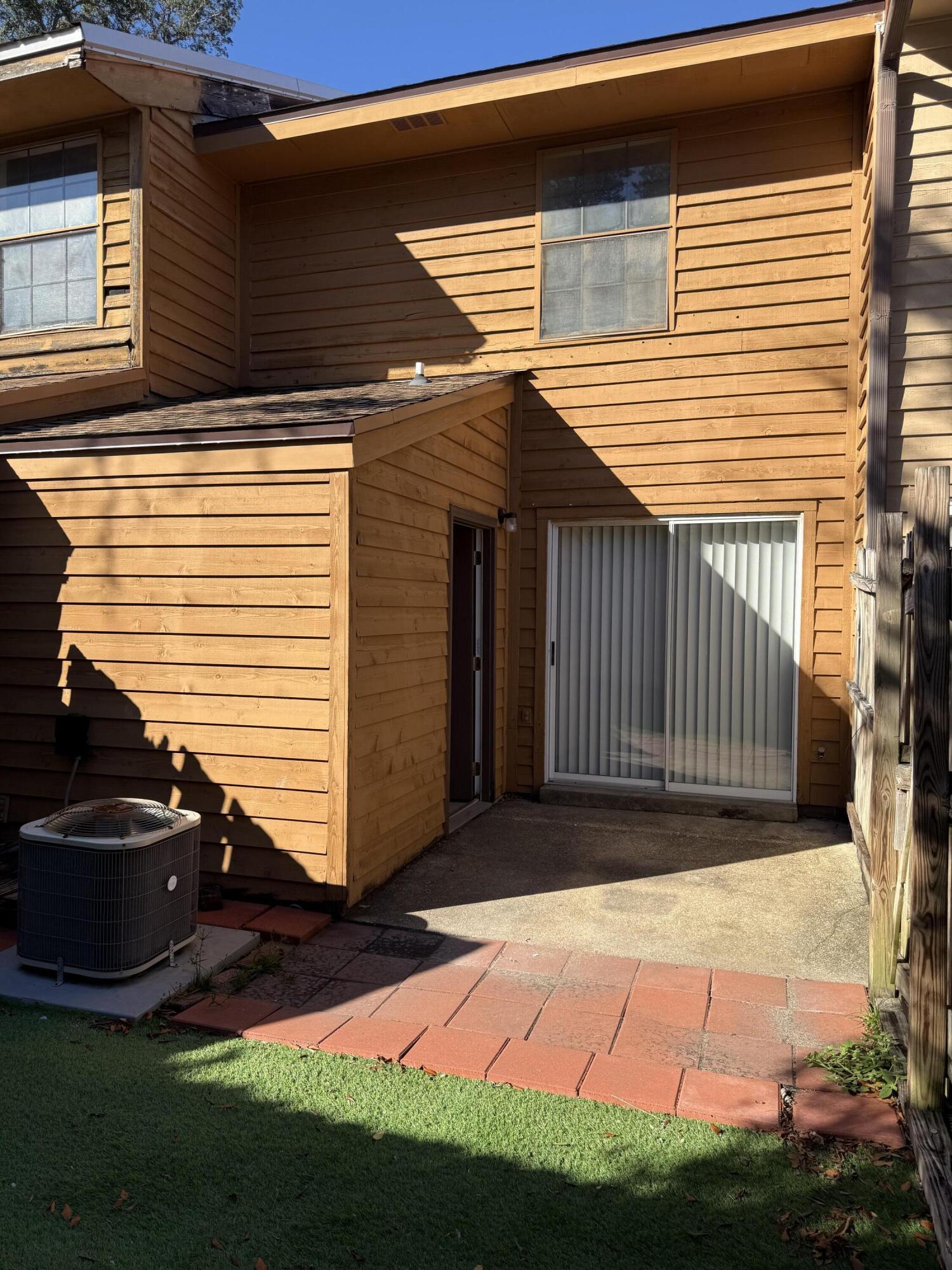 226 Pelham Road, Unit 6 Fort Walton Beach, FL 32547 - Photo 2 of 11 a view of backyard with barbeque grill and wooden fence