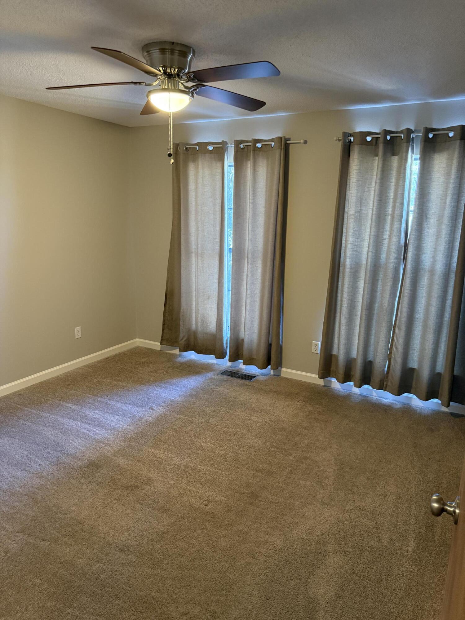 226 Pelham Road, Unit 6 Fort Walton Beach, FL 32547 - Photo 9 of 11 an empty room with a chandelier fan and a window