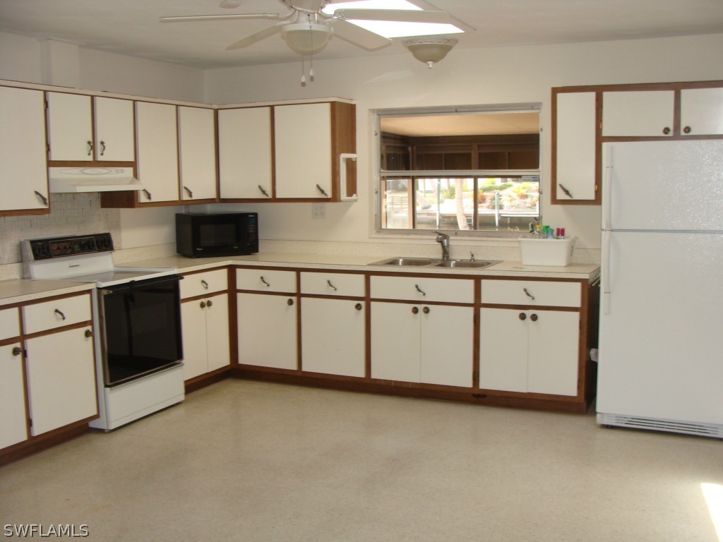 3269 Stringfellow Road St. James City, FL 33956 - Photo 8 of 22 a kitchen with white cabinets sink and white appliances