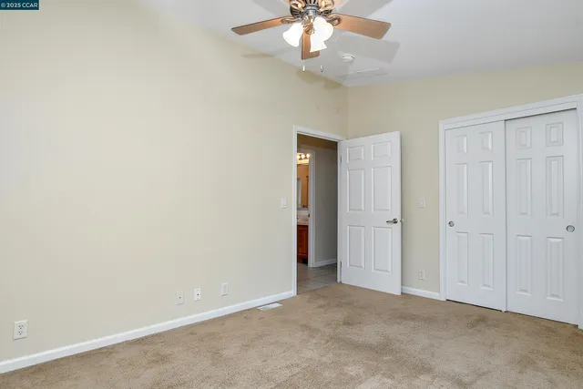 an empty room with a chandelier fan