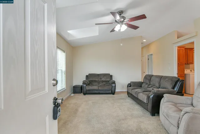 a living room with furniture and a ceiling fan