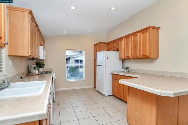 a kitchen with a sink a refrigerator and cabinets