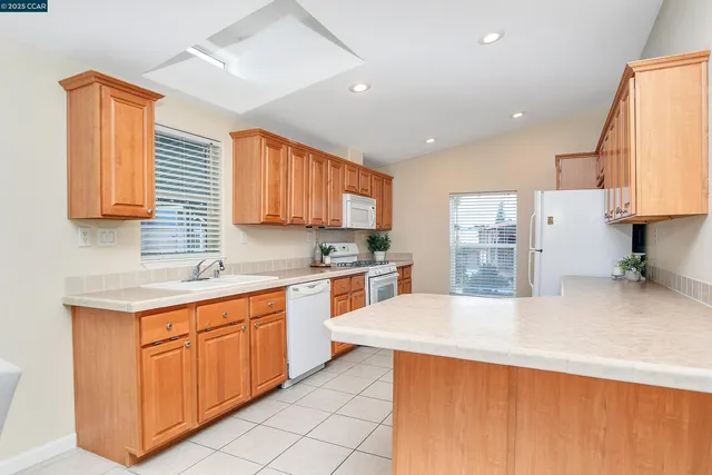 a kitchen with granite countertop a sink stainless steel appliances and cabinets