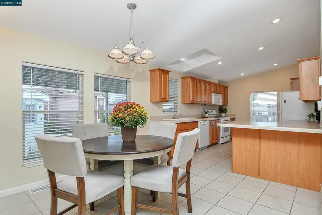 a dining room filled chandelier and kitchen view