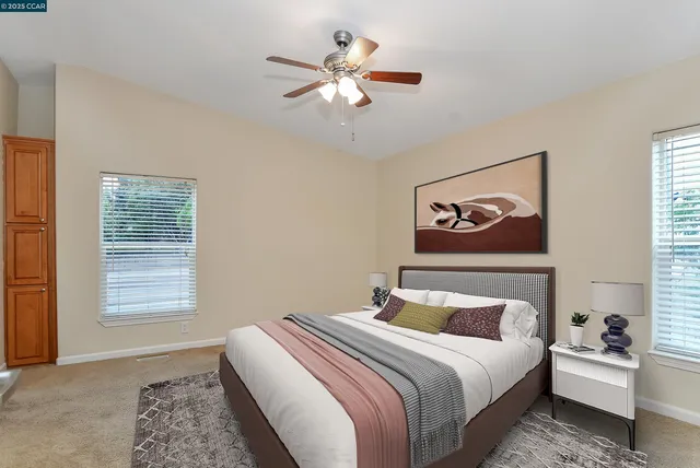 a bedroom with bed painting on wall and a window