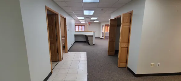 a view of a hallway with a refrigerator and chandelier