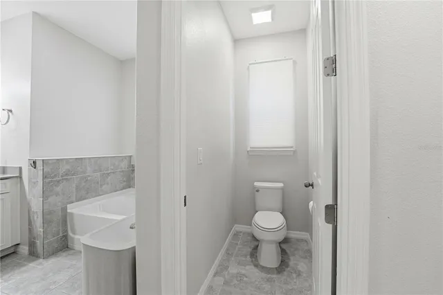 a large bedroom with a bed and a refrigerator