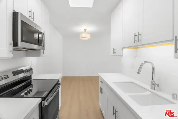 a kitchen with a sink stove and microwave