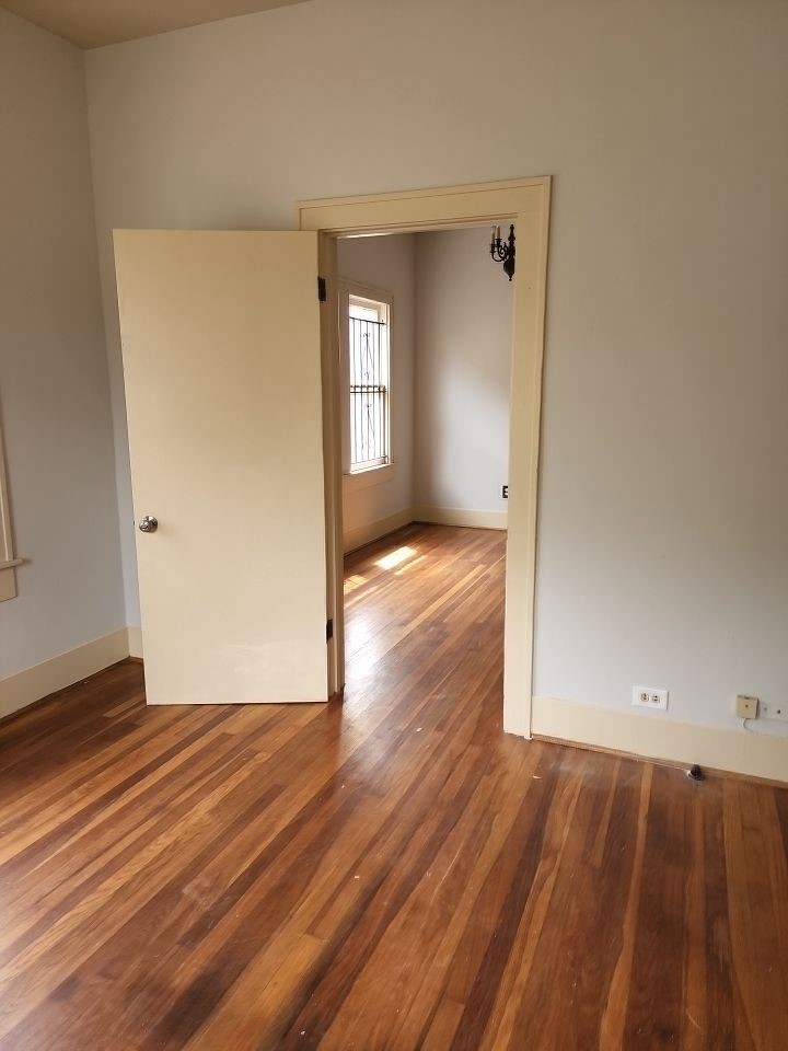 4716 Crawford Street Houston, TX 77004 - Photo 11 of 14 wooden floor in an empty room with a window