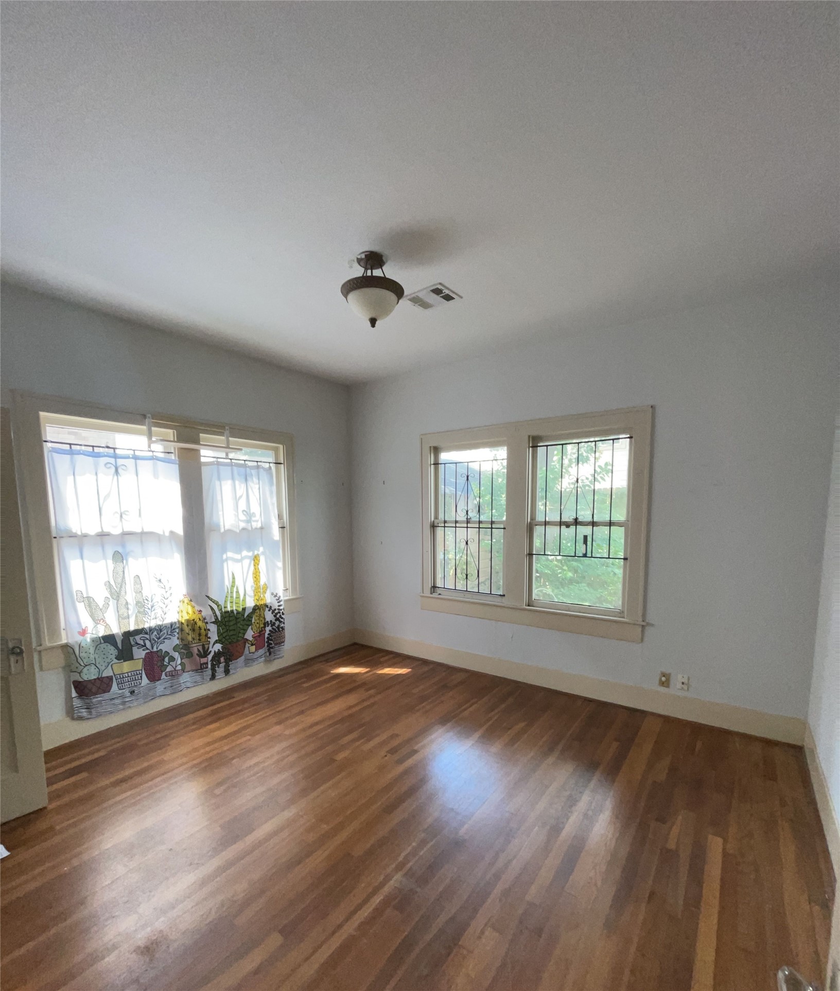 4716 Crawford Street Houston, TX 77004 - Photo 6 of 14 a view of an empty room with a window and wooden floor