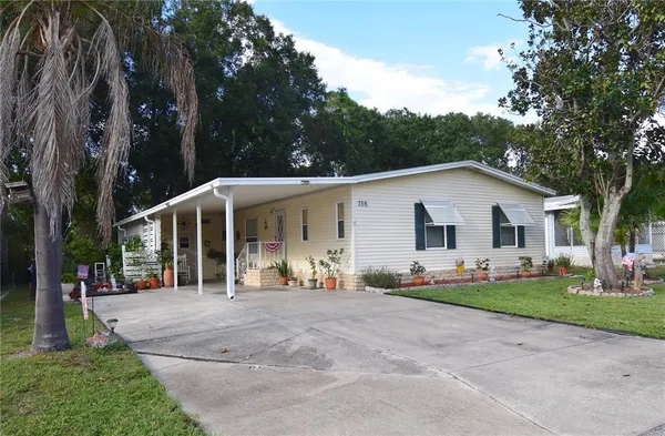 a view of a white house with a yard and sitting area