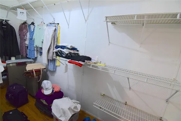 a view of walk in closet with clothes and shoes