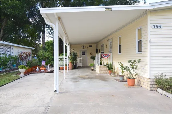 a view of a patio with table and chairs potted plants