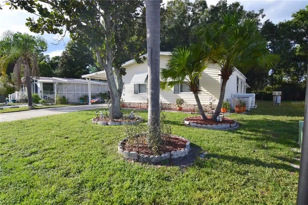 a front view of a house with garden and trees