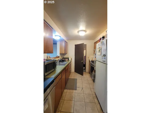 a view of a big house with a big yard and large tree