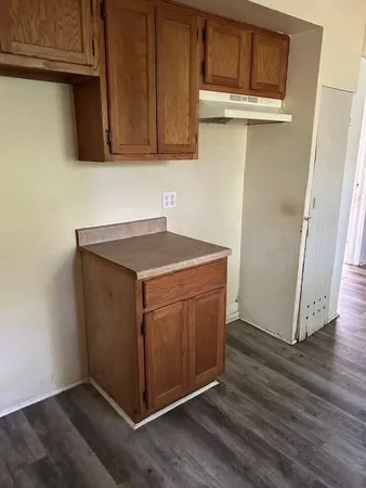 a utility room with wooden floor washer and dryer