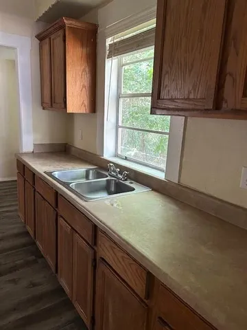 a kitchen with a sink a window and cabinets