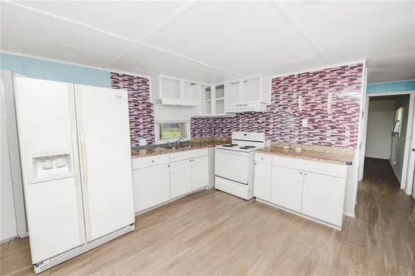 a kitchen with white cabinets and white appliances
