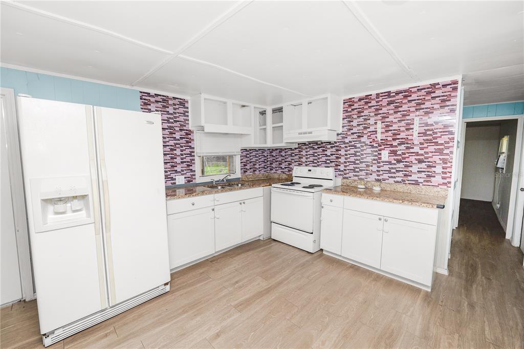 829 Nashville Road Lakeland, FL 33815 - Photo 11 of 30 a kitchen with white cabinets and white appliances