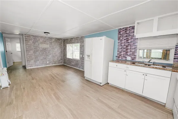 a kitchen with granite countertop white cabinets and refrigerator
