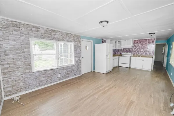 a view of empty room with a kitchen and a window