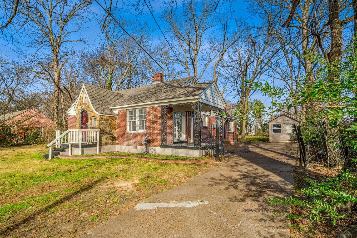 1114 Brownlee Road Memphis, TN 38116 - Photo 4 of 32 View of front of house with an outdoor structure, brick siding, a chimney, driveway, and a front lawn
