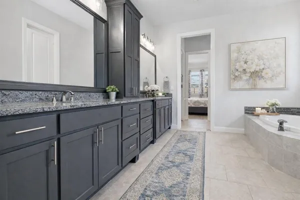 a spacious bathroom with a tub sink and mirror