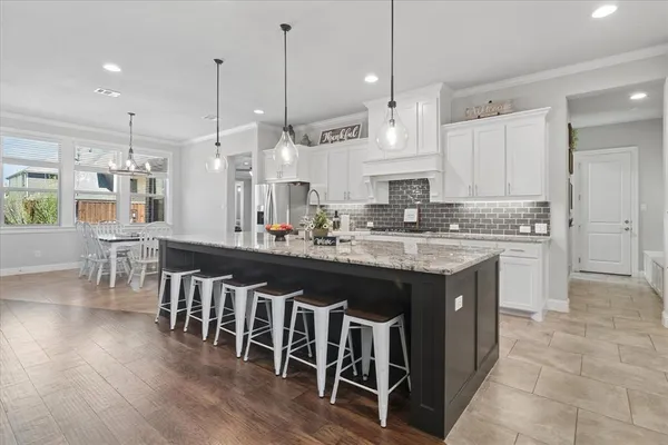 a kitchen with stainless steel appliances granite countertop a stove a sink island and a wooden cabinets