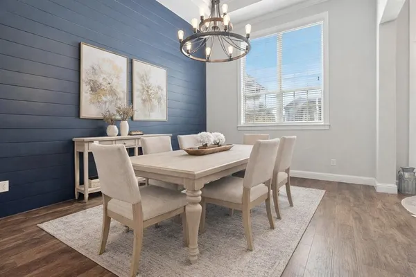 a dining room with furniture a chandelier and window