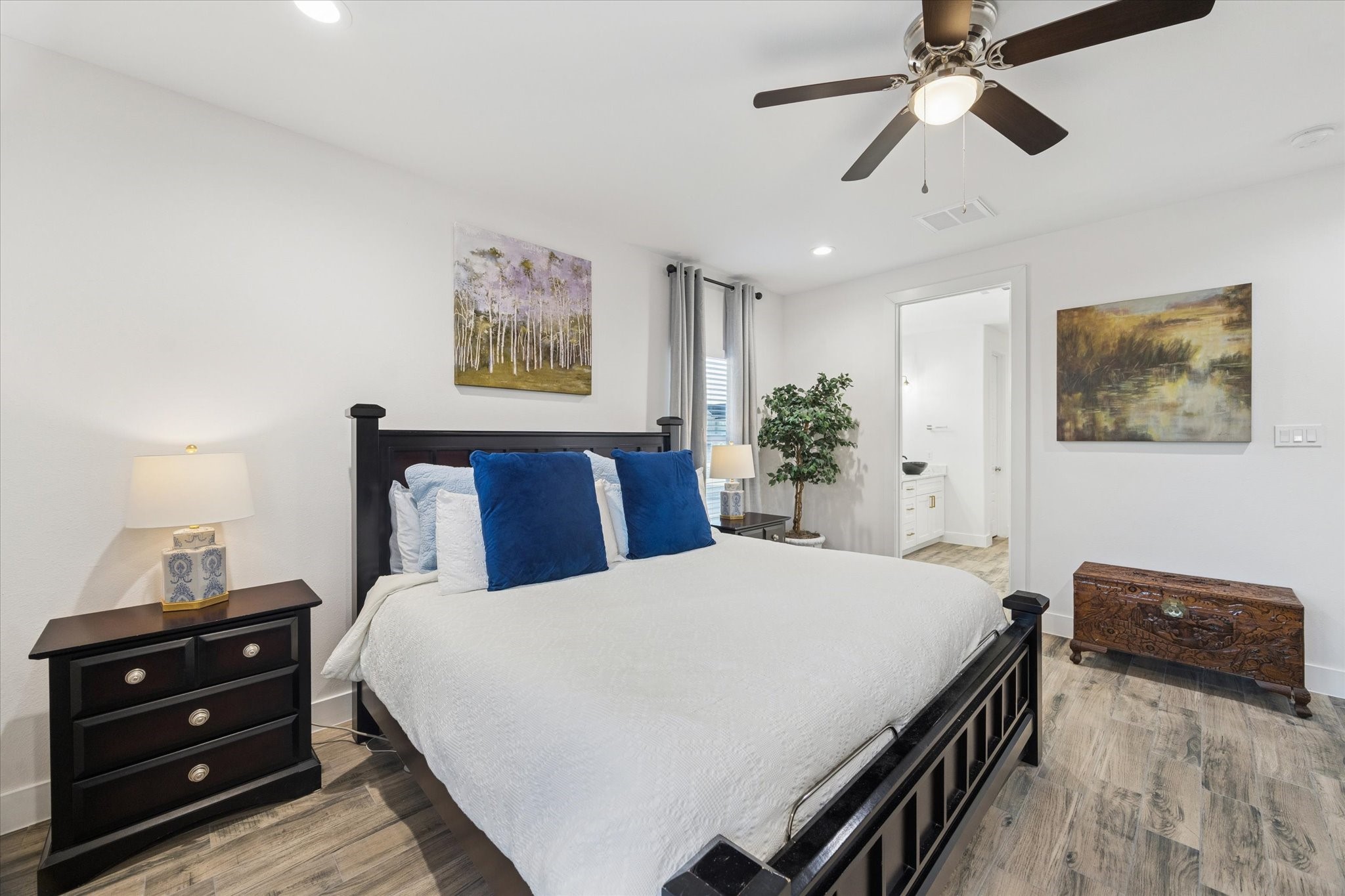 203 Hampton Glen Road Montgomery, TX 77356 - Photo 17 of 35 This angle of the primary bedroom highlights its generous size and abundant natural light, creating a bright and inviting retreat. The view also showcases the convenient location of the ensuite bathroom, emphasizing a seamless and functional layout. The combination of space, light, and thoughtful design creates a truly luxurious primary suite.