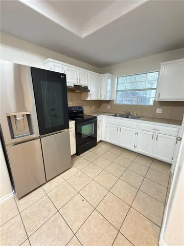 a kitchen with stainless steel appliances a refrigerator sink and microwave
