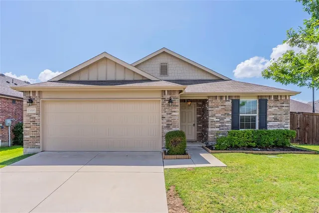 a front view of a house with a yard and potted plants