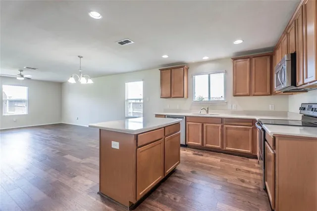 a kitchen with a sink window and cabinets