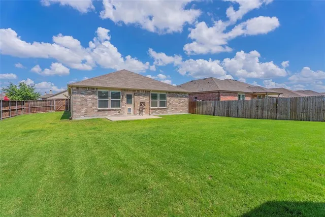 a view of a house with a big yard and large trees