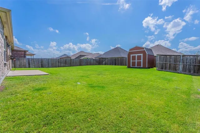 a view of a house with a yard and large trees