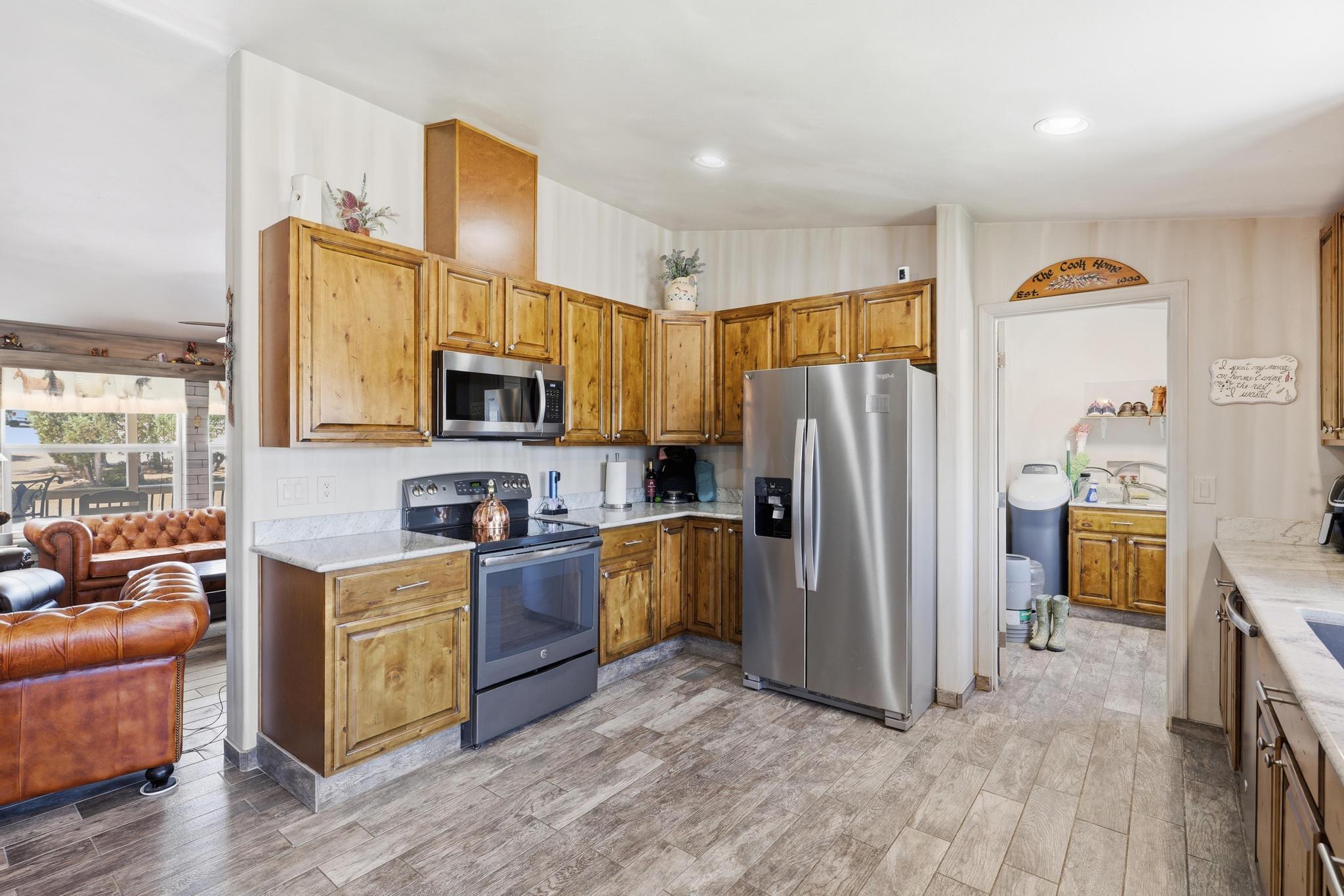 1211 Heather Circle Payson, AZ 85541 - Photo 11 of 51 a kitchen with stainless steel appliances granite countertop a refrigerator a stove top oven a sink dishwasher and wooden cabinets with wooden floor