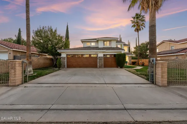 a view of a house with a yard and potted plants