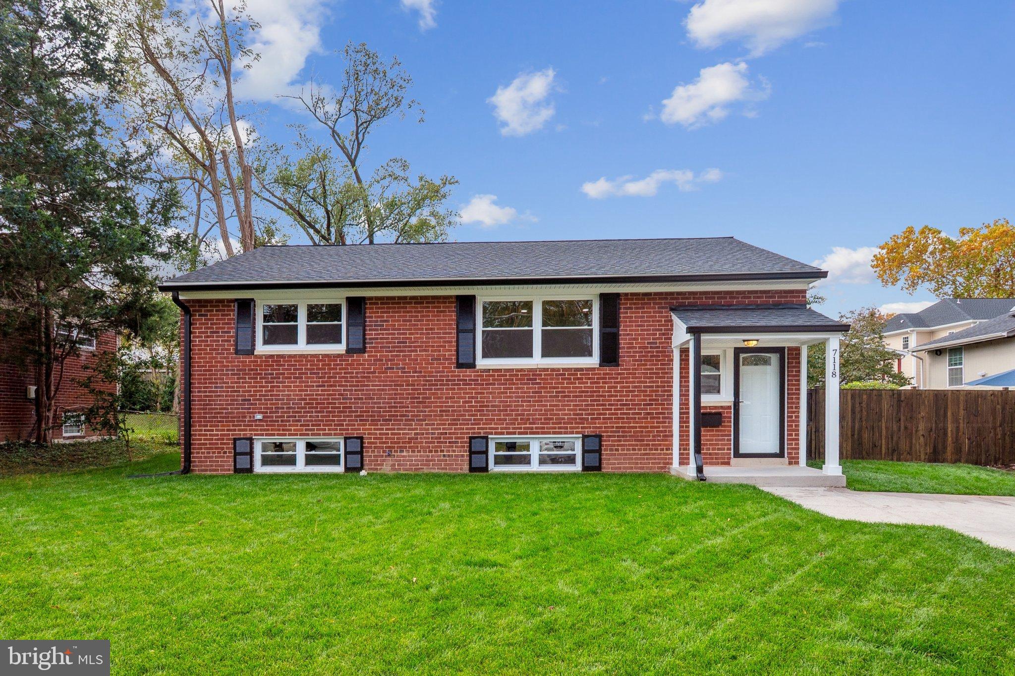 Charming brick home with lush green lawn.