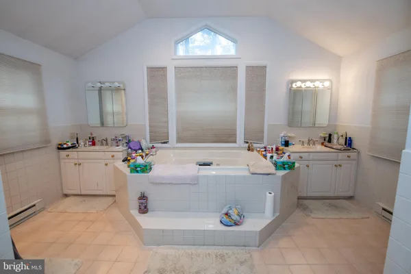 a bathroom with a tub sink and mirror