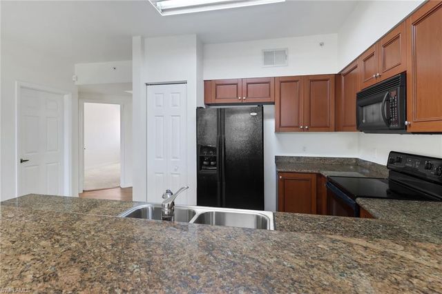 a kitchen with stainless steel appliances granite countertop a refrigerator a stove a sink and a granite counter tops