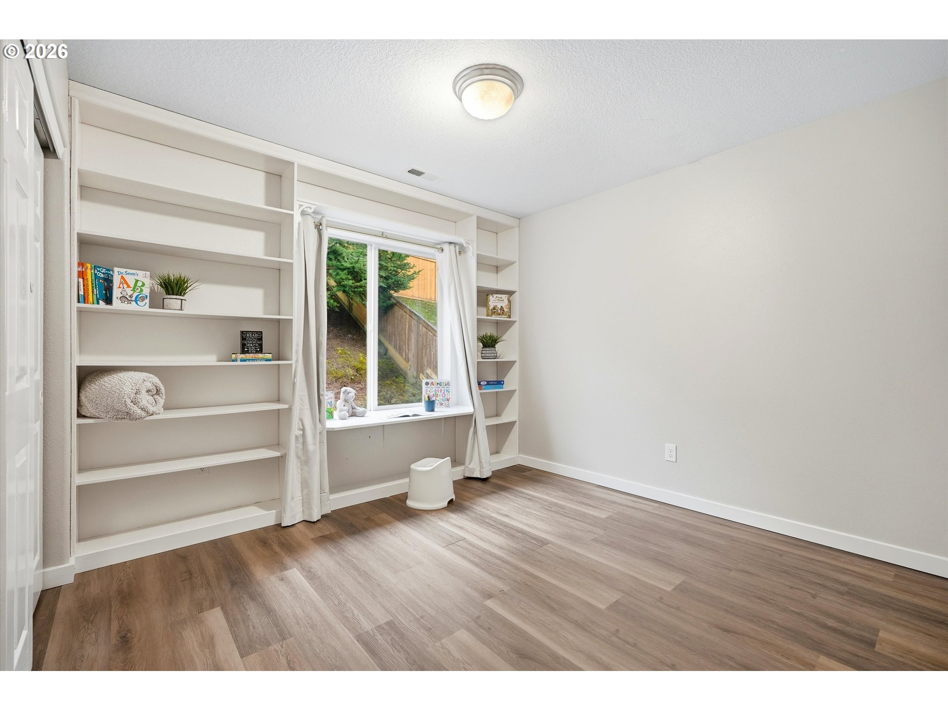 3130 Northwest Pacific Rim Drive Camas, WA 98607 - Photo 18 of 33 a view of an empty room with a window and wooden floor
