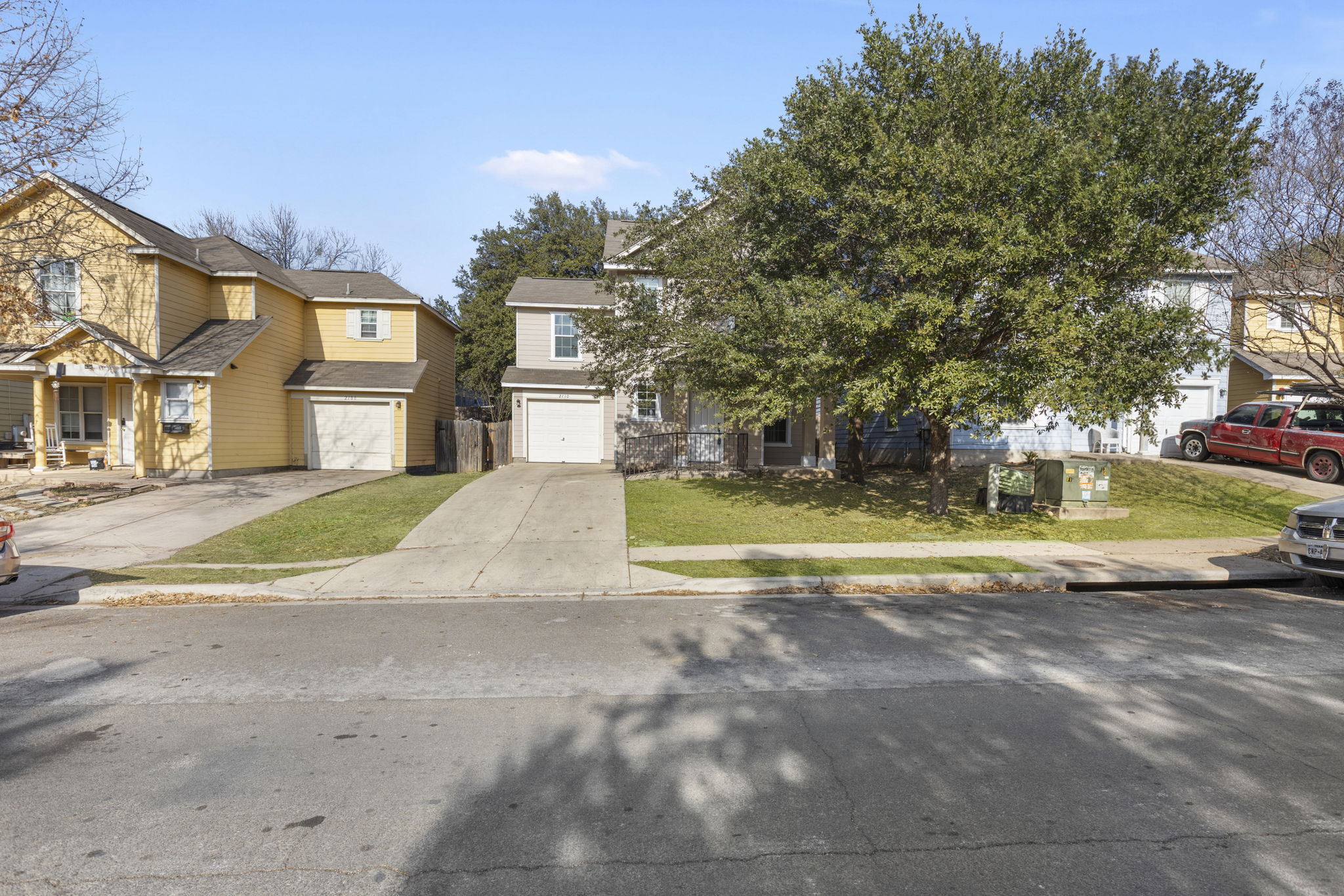 2110 Nogales Trail Austin, TX 78744 - Photo 2 of 37 View of front of house featuring driveway, a residential view, a front yard, and an attached garage. Virtual grass.