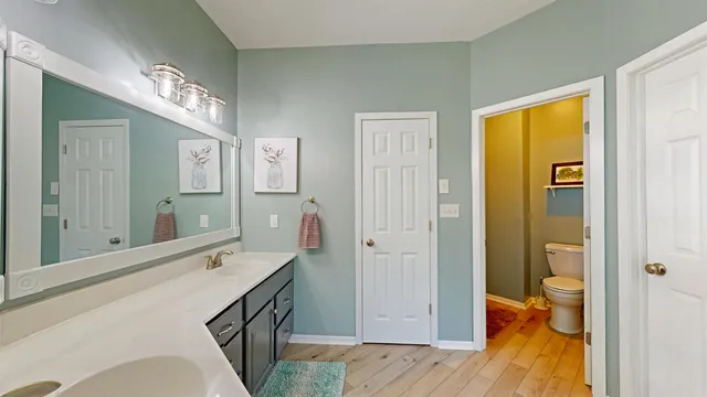 a spacious bathroom with a double vanity sink a large mirror and a shower