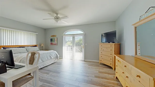 a spacious bedroom with a bed and wooden floor