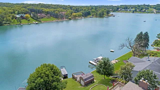 an aerial view of a house with a yard and lake view