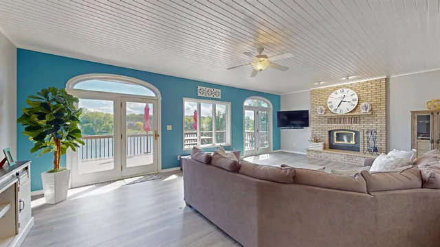 a living room with furniture a fireplace and a large window