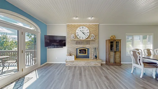 a view of a livingroom with furniture a fireplace and wooden floor
